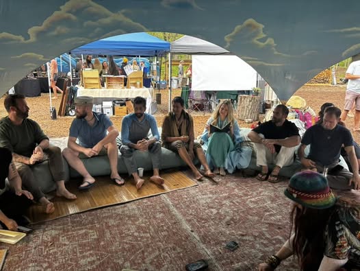 The CATALY$T REVIVAL speaker panel: seven people on a low couch under a tent in Asheville
